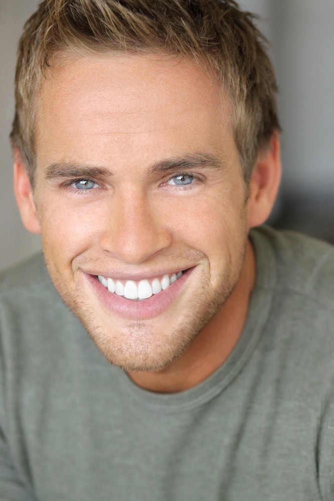 Close-up portrait of a young attractive man with great toothy smile